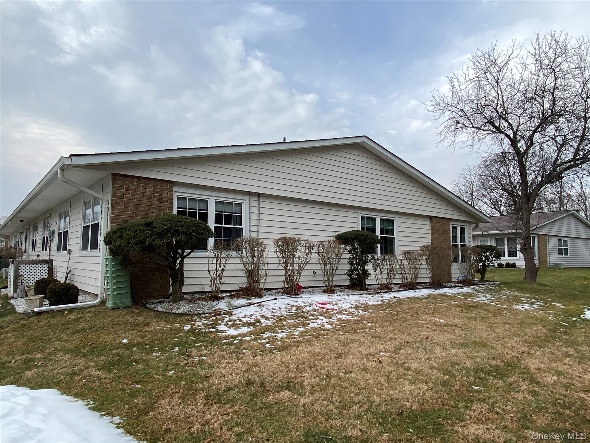 274 Berwick Court, Unit A Ridge, NY 11961 - Photo 2 of 26 a view of a house with a large window and a yard with seating space