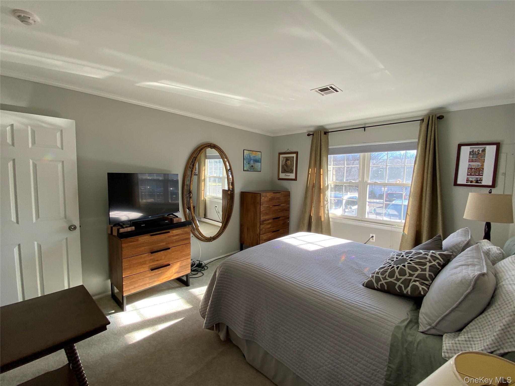 274 Berwick Court, Unit A Ridge, NY 11961 - Photo 25 of 26 a bed room with a bed mirror and a window