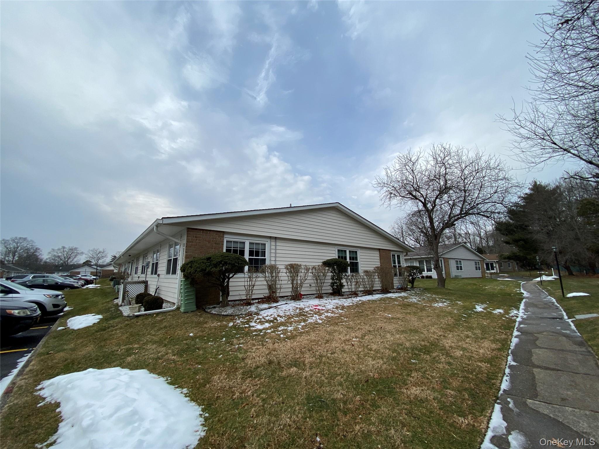274 Berwick Court, Unit A Ridge, NY 11961 - Photo 4 of 26 a front view of a house with a yard and garage