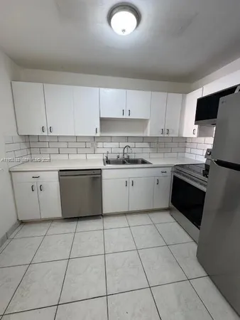 a kitchen with a sink a stove a microwave and cabinets