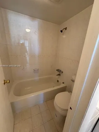 an empty room with windows and ceiling fan