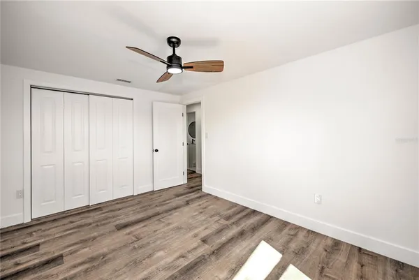 a view of empty room with wooden floor
