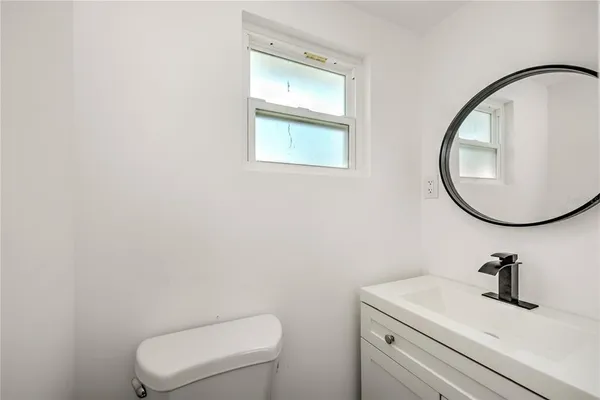 a bathroom with a toilet a sink and mirror