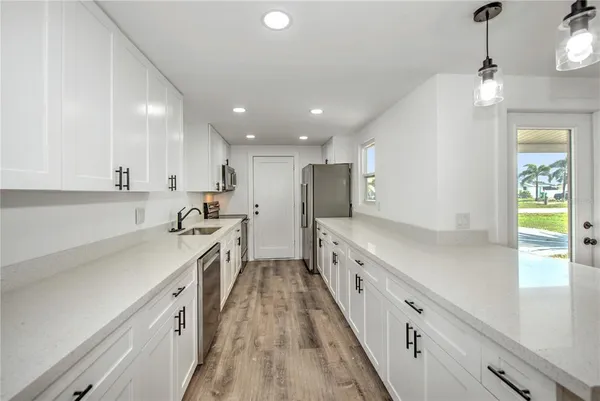 a kitchen with white cabinets sink and stainless steel appliances
