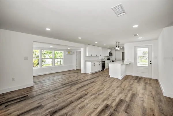 a view of a kitchen with a sink and wooden floor