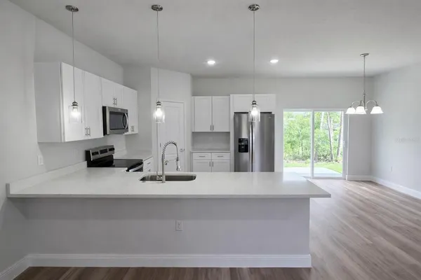 a kitchen with cabinets stainless steel appliances and sink