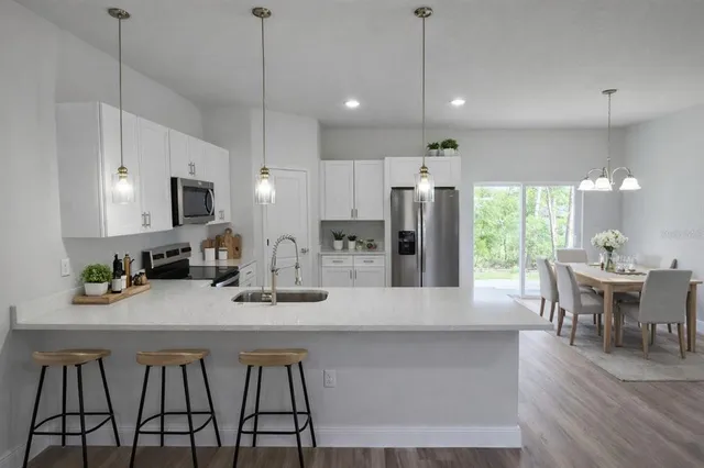 a view of a hallway with wooden floor and a bathroom