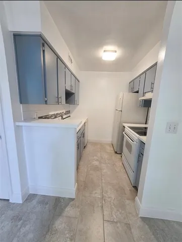 a kitchen with a stove top oven and cabinets
