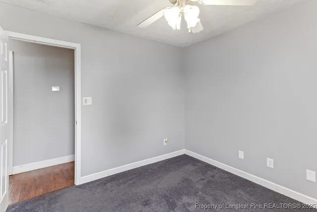 an empty room with a chandelier fan