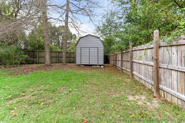 a house that is sitting in the grass with wooden fence