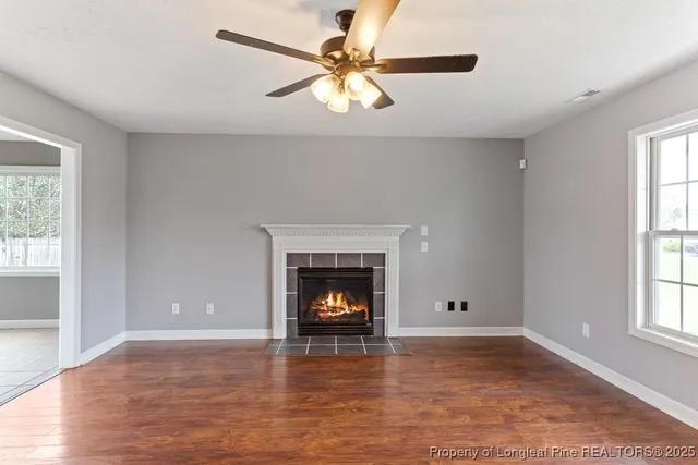 an empty room with windows and fireplace