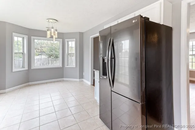 a view of a refrigerator in kitchen and windows