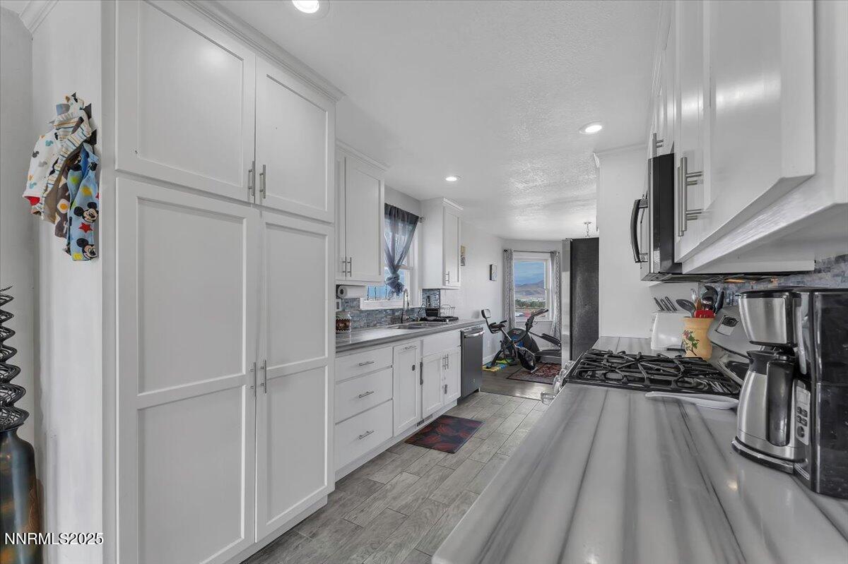 20 Simons Road Fernley, NV 89408 - Photo 13 of 56 a kitchen with white cabinets and appliances