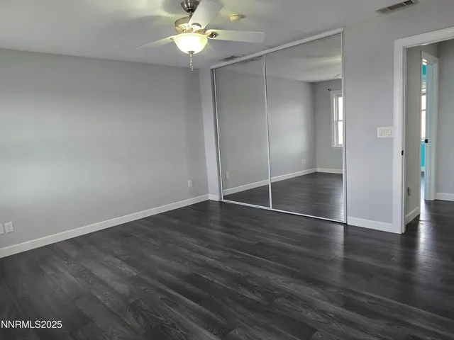 an empty room with wooden floor and window