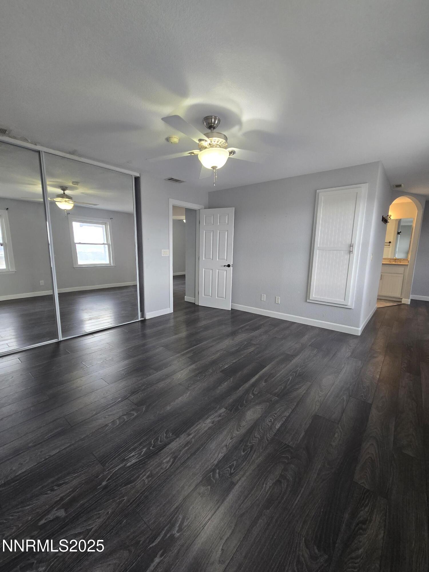 20 Simons Road Fernley, NV 89408 - Photo 18 of 56 an empty room with wooden floor chandelier fan and windows