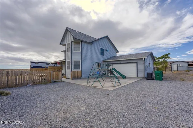 a view of a dry yard with a large tree