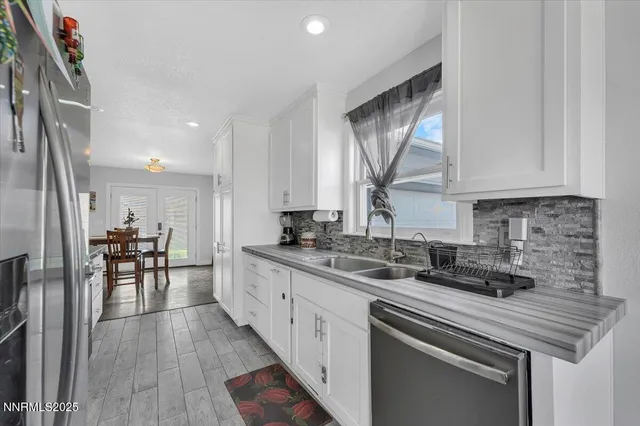 a kitchen with stainless steel appliances granite countertop a sink a stove and a refrigerator