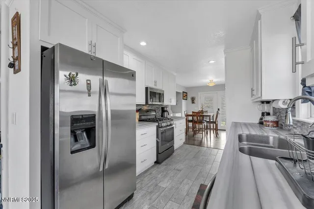 a kitchen with stainless steel appliances a refrigerator sink and cabinets
