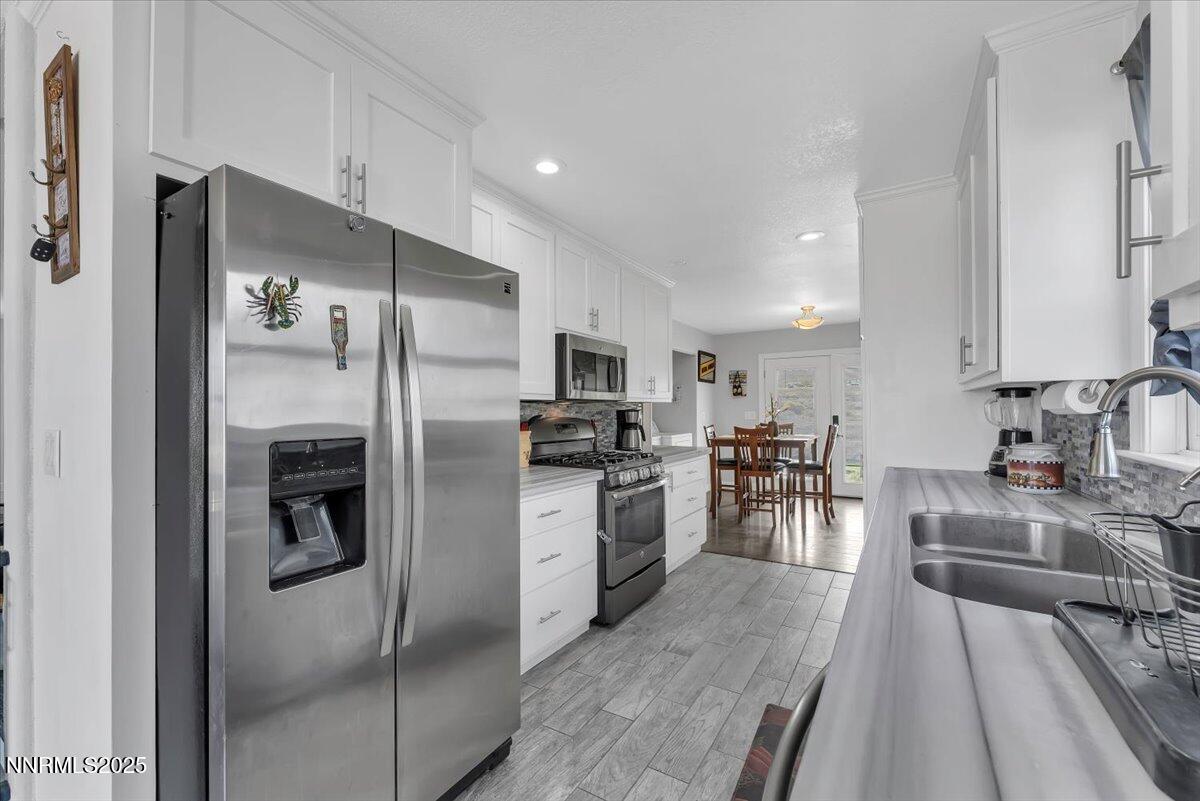 20 Simons Road Fernley, NV 89408 - Photo 10 of 56 a kitchen with a refrigerator a sink a stove top oven and chairs