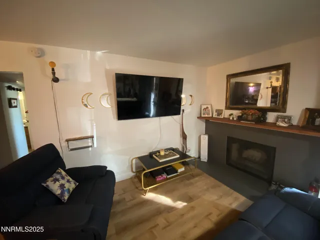 a living room with furniture a flat screen tv and a fireplace