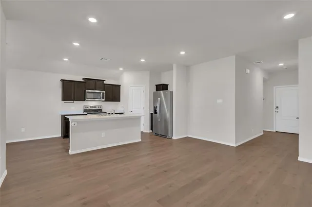 a view of cabinets a microwave oven a sink and dishwasher with wooden floor