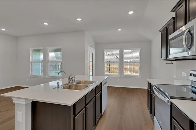 a kitchen with sink stove and microwave