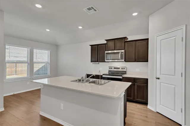 a kitchen that has a sink and a stove top oven