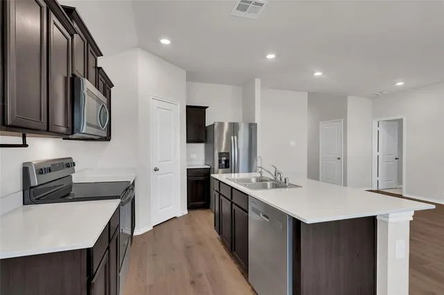 a kitchen with stainless steel appliances a sink stove and refrigerator