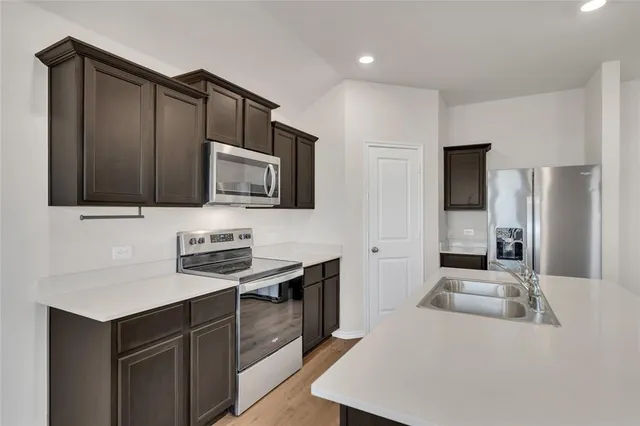 a kitchen with stainless steel appliances a stove sink microwave and cabinets