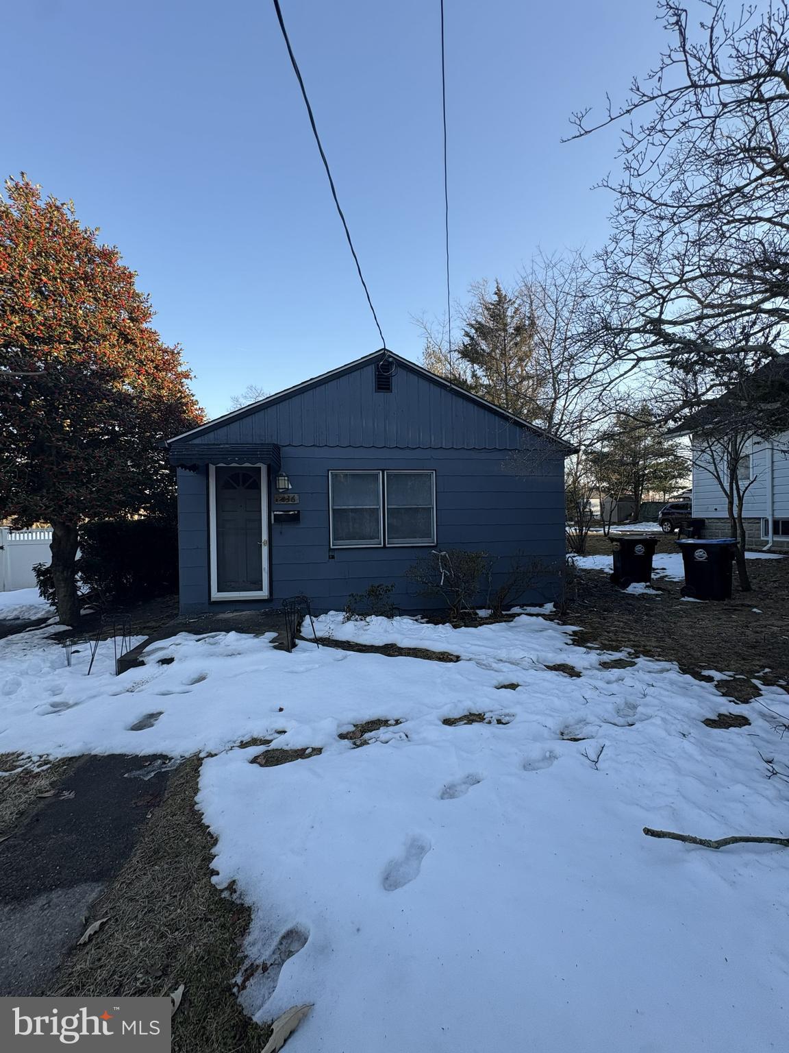 a front view of a house with a yard covered in snow