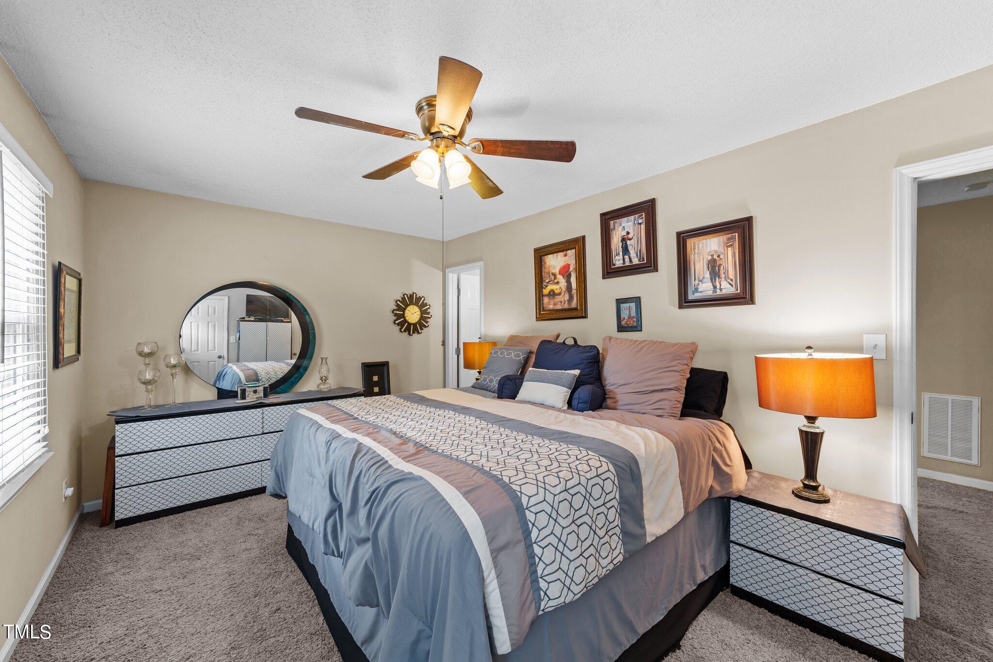 4600 Jacqueline Lane Raleigh, NC 27616 - Photo 24 of 34 a bedroom with a bed lamp and a window