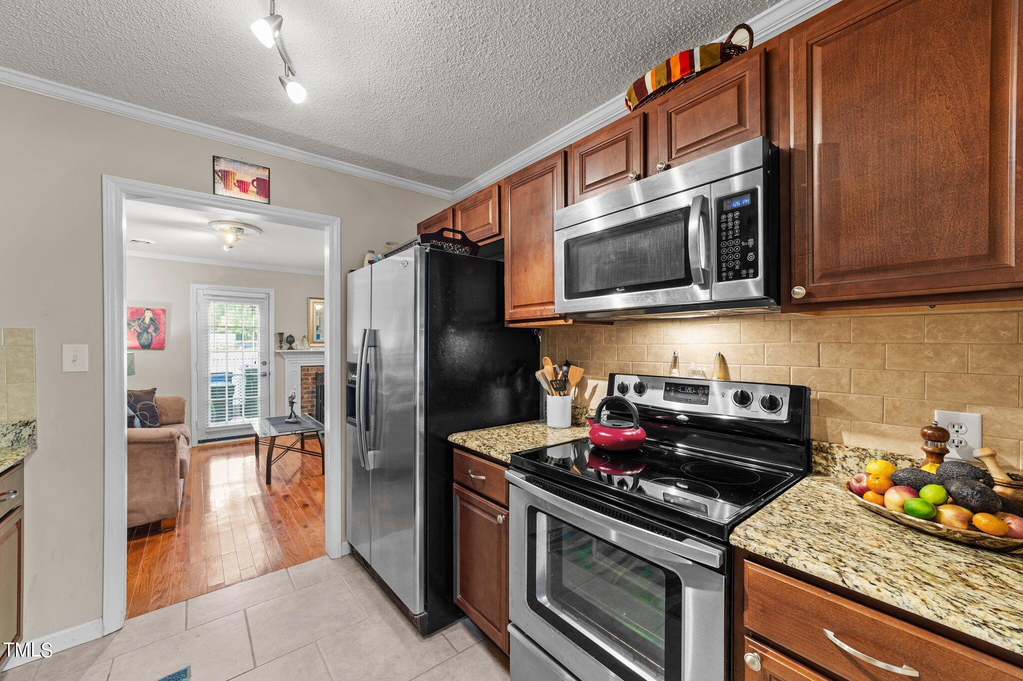 4600 Jacqueline Lane Raleigh, NC 27616 - Photo 8 of 34 a kitchen with stainless steel appliances granite countertop a stove and a refrigerator