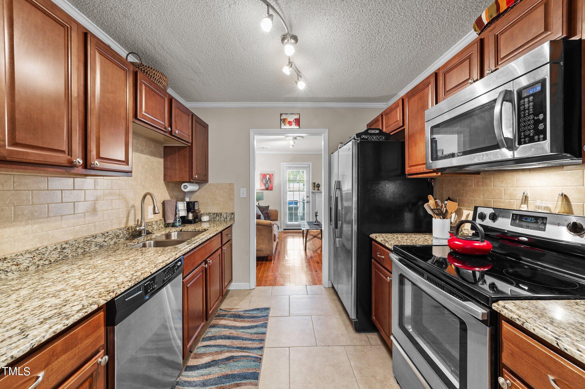4600 Jacqueline Lane Raleigh, NC 27616 - Photo 10 of 34 a kitchen with stainless steel appliances granite countertop a sink stove and refrigerator