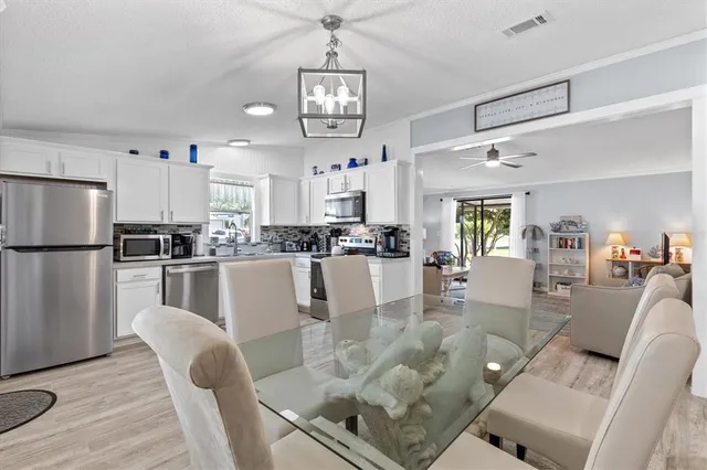 a living room with stainless steel appliances furniture and a chandelier