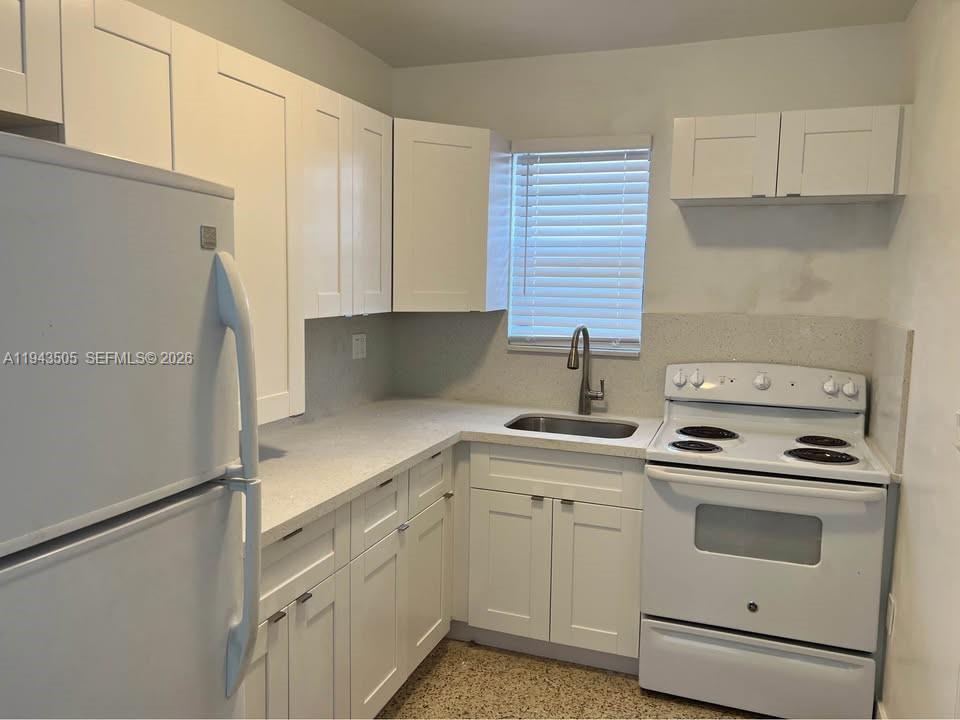 a kitchen with white cabinets and white appliances