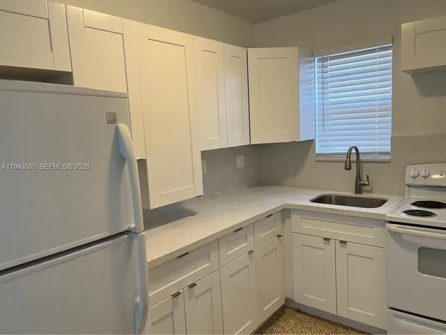 a kitchen with stainless steel appliances white cabinets and a refrigerator