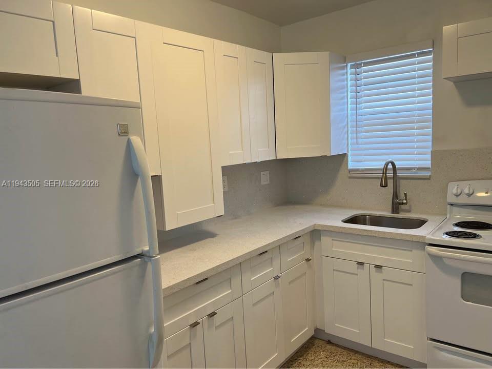 59 East 20th Street, Unit 59 Hialeah, FL 33010 - Photo 2 of 10 a kitchen with stainless steel appliances white cabinets and a refrigerator