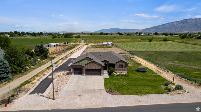 5702 950 North Ogden, UT 84404 - Photo 5 of 36 Brick residence featuring a two-car garage, concrete driveway, and a verdant lawn