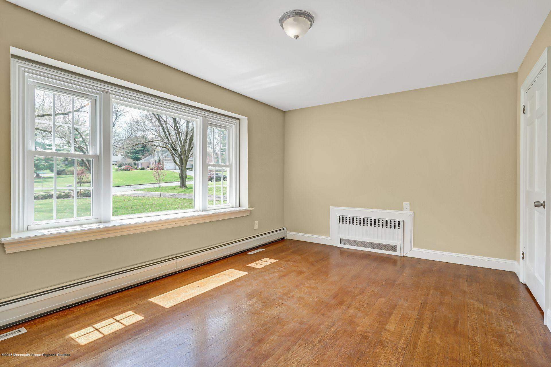 8 Saddle Ridge Road Colts Neck, NJ 07722 - Photo 16 of 35 a view of an empty room with a window and wooden floor