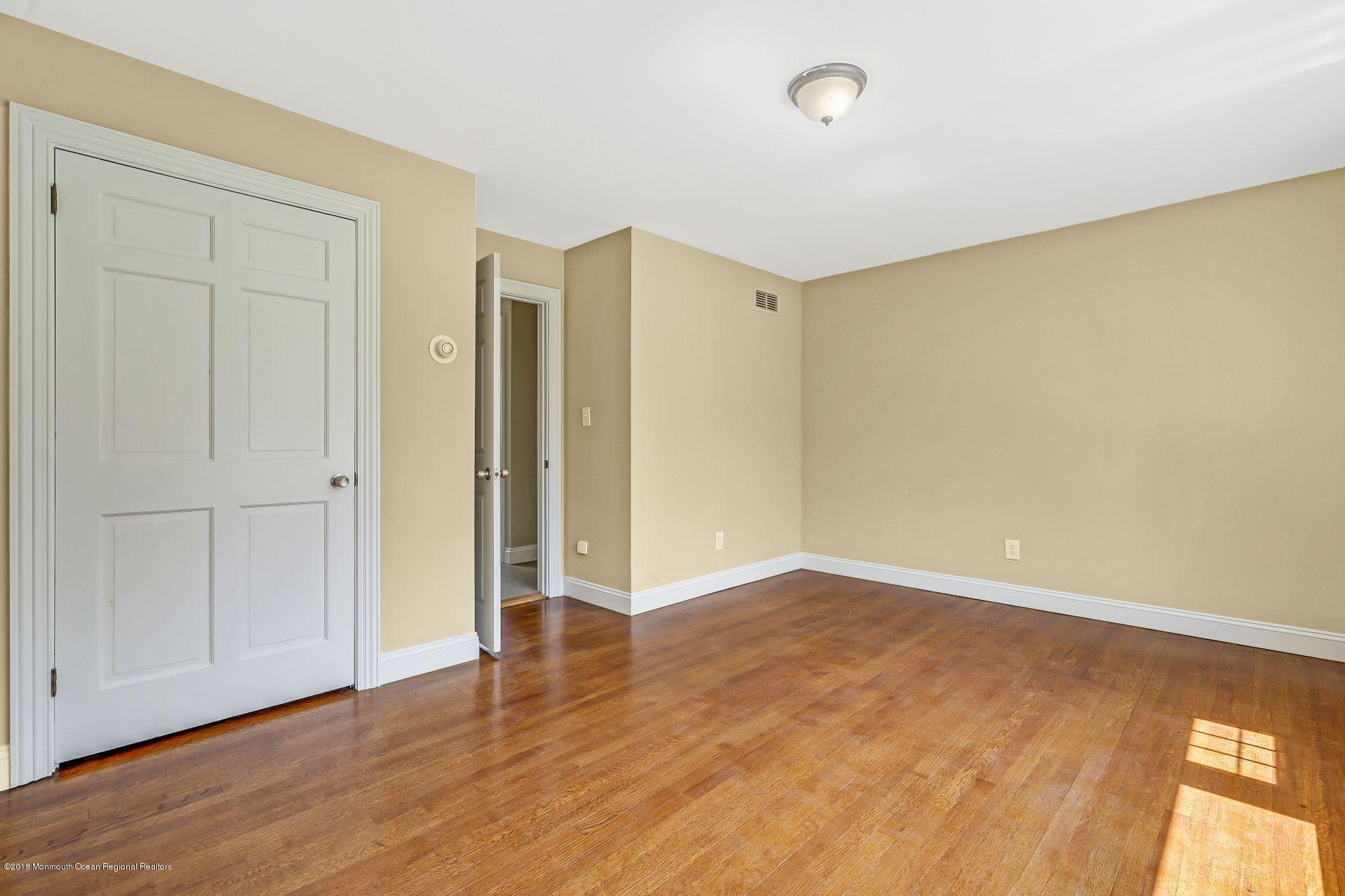 8 Saddle Ridge Road Colts Neck, NJ 07722 - Photo 17 of 35 an empty room with wooden floor and windows