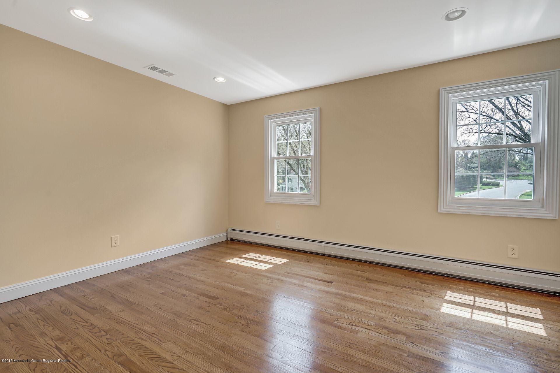 8 Saddle Ridge Road Colts Neck, NJ 07722 - Photo 23 of 35 a view of an empty room with wooden floor and a window