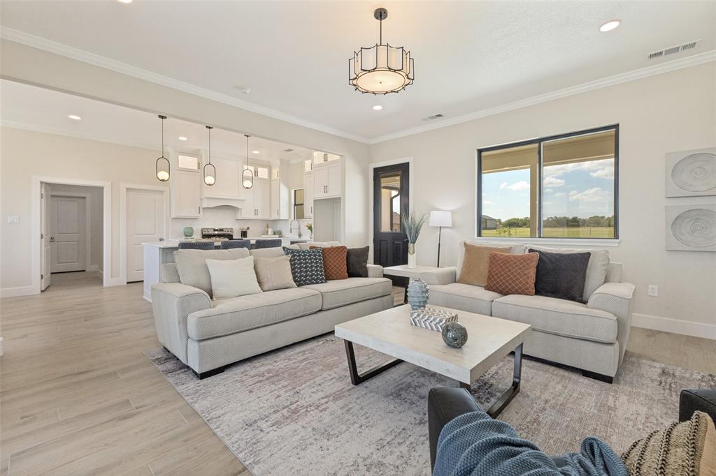 3150 Crisp Road Ennis, TX 75119 - Photo 3 of 30 Open-concept living area featuring light wood-finish flooring, a contemporary chandelier, and recessed lighting