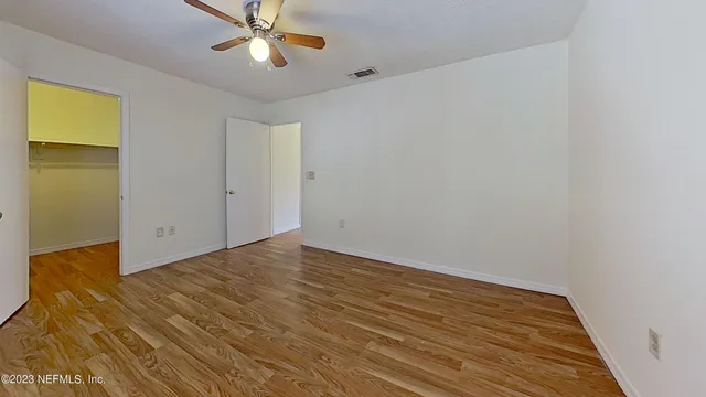 a view of an empty room with wooden floor