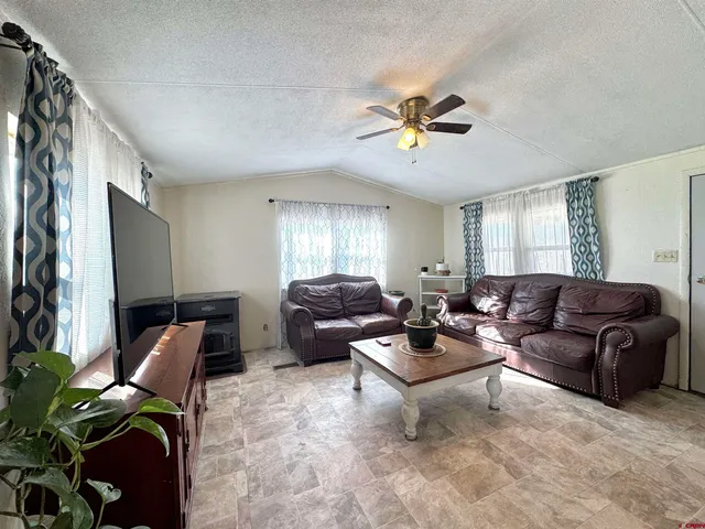 a living room with furniture ceiling fan and a window