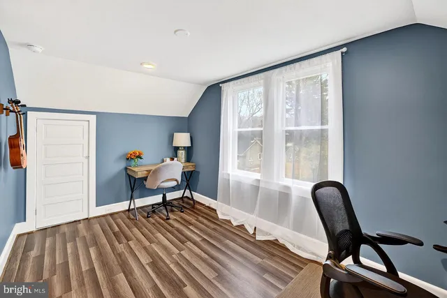 a work room with furniture wooden floor and a window
