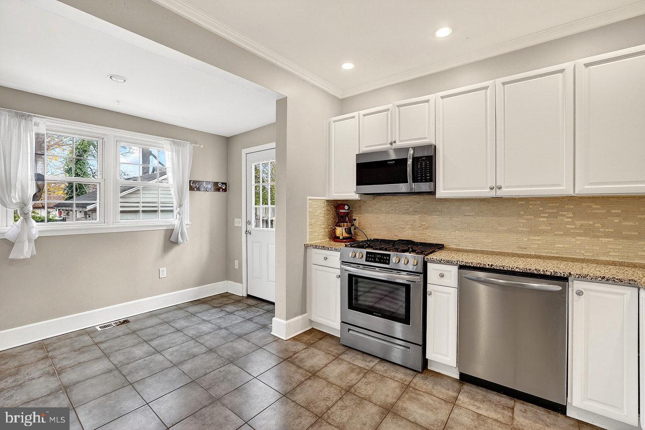 512 Spruce Street Delanco, NJ 08075 - Photo 10 of 24 a kitchen with granite countertop a stove top oven microwave and cabinets