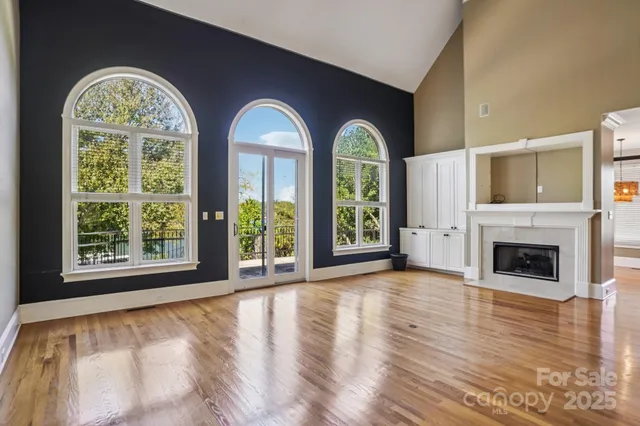 a view of an empty room with a fireplace and a window