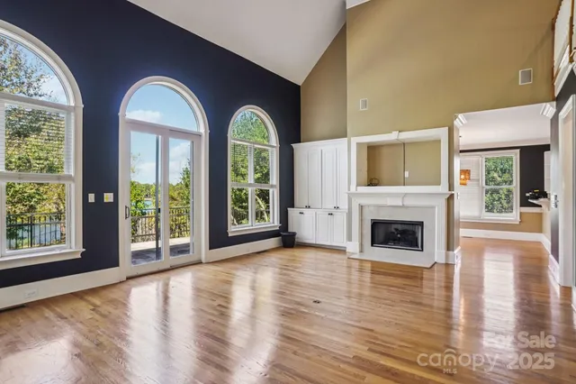 a view of empty room with fireplace and wooden floor