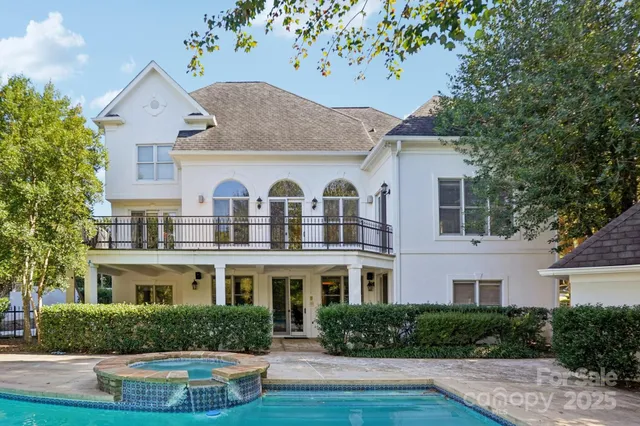 a view of a white house with a yard and potted plants
