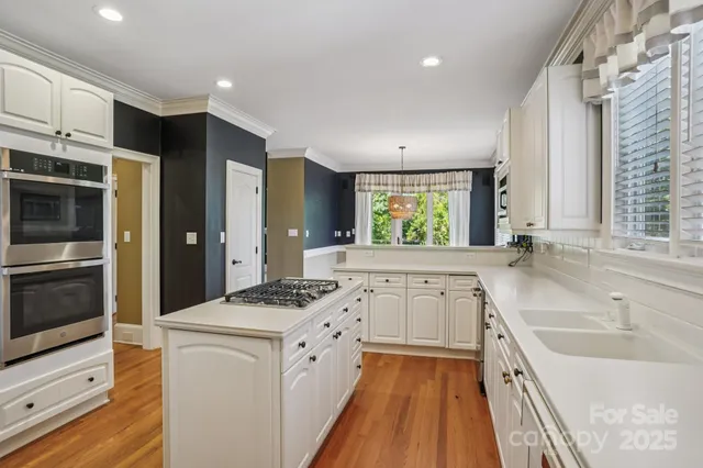 a kitchen with granite countertop a sink stove and refrigerator